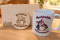 Dreiteiliges Fledermaus-Geschenkset mit weißer Motivtasse, graviertem Frühstücksbrettchen aus Buchenholz und rundem Holzuntersetzer.