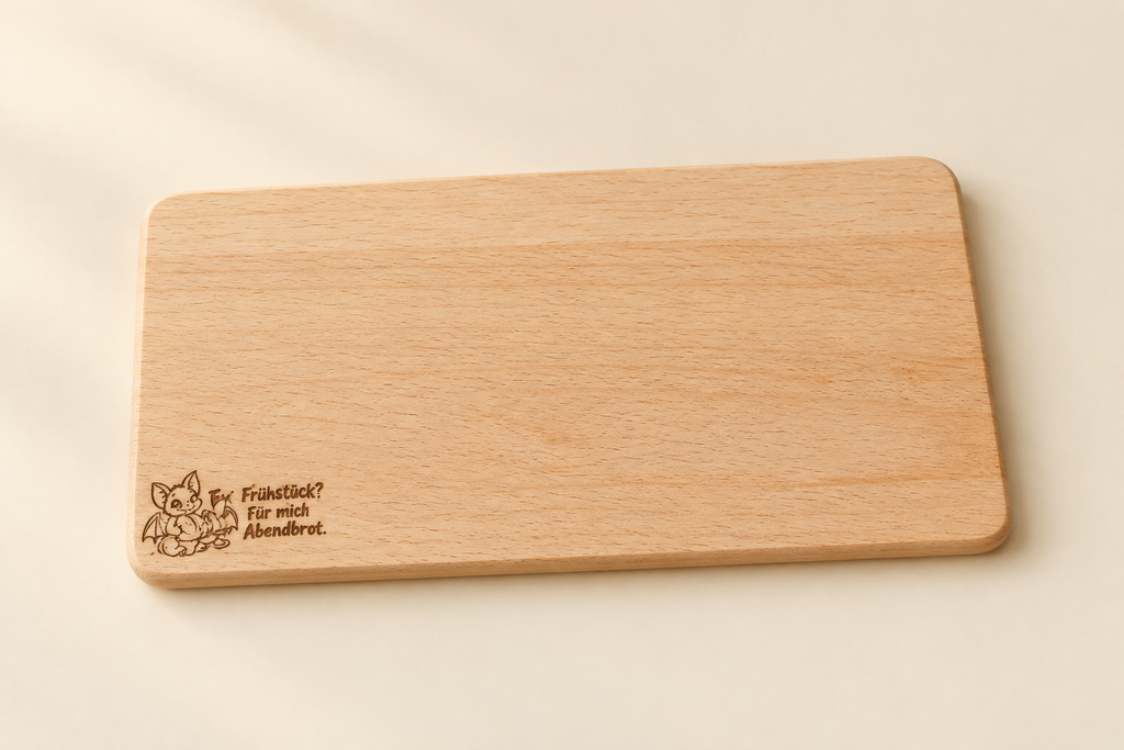 „Holz-Frühstücksbrettchen mit kleiner Fledermausgravur unten links und dem Spruch ‚Frühstück? Für mich Abendbrot.‘“