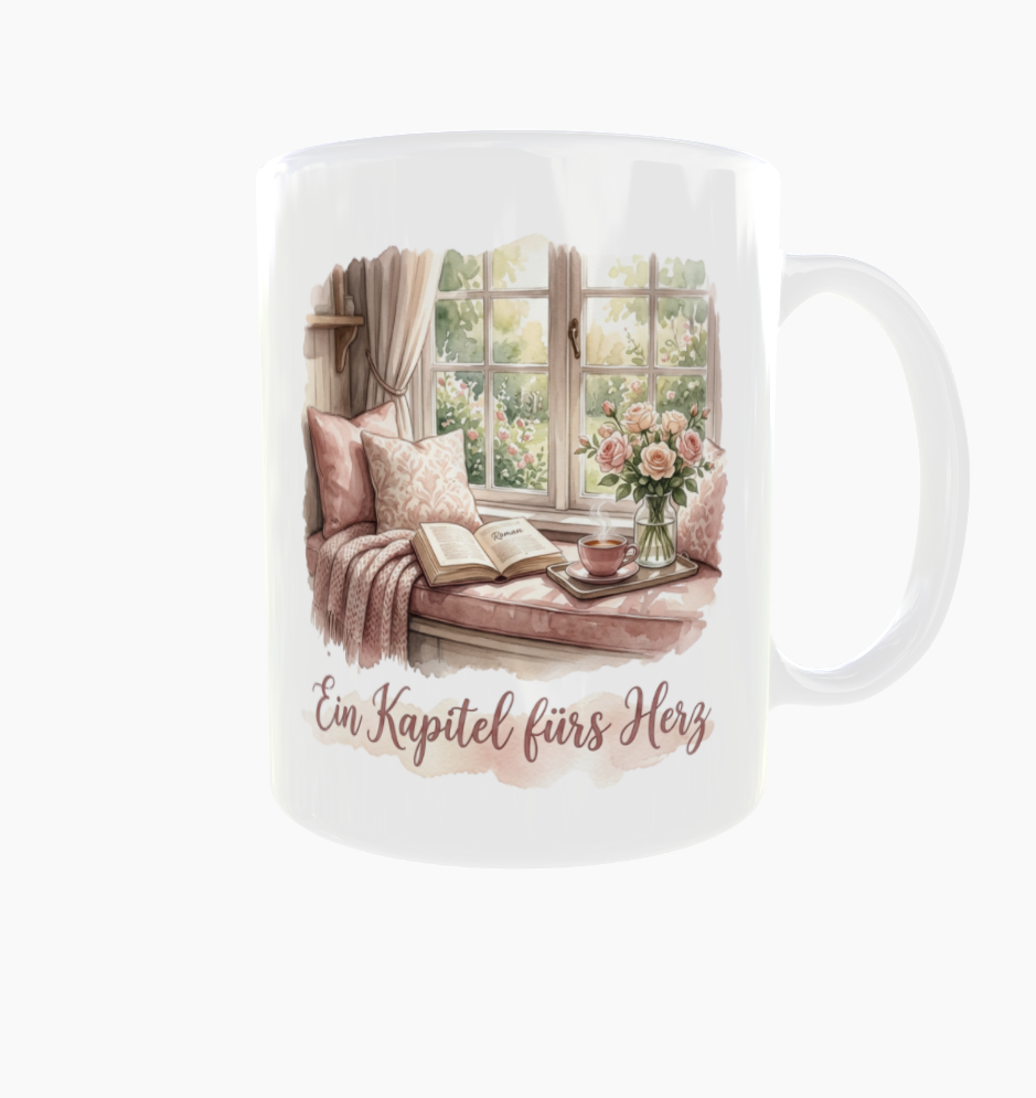 Weiße Tasse „Ein Kapitel fürs Herz“ mit Henkel rechts und Fensterplatz mit rosafarbenen Kissen, Buch, Tee und Rosen.